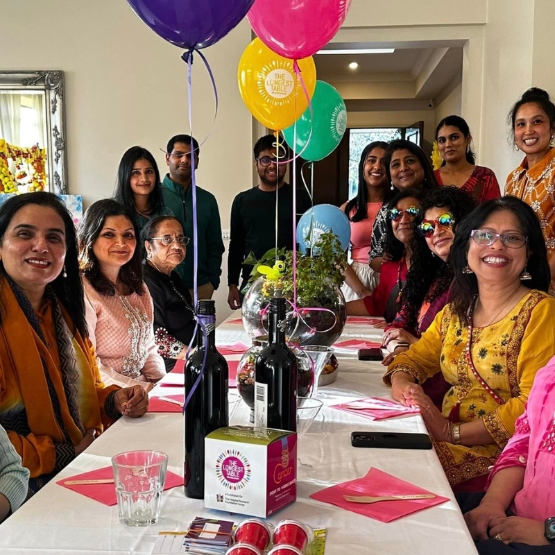 alt='TLT-Host_Family Gathered at the Table'